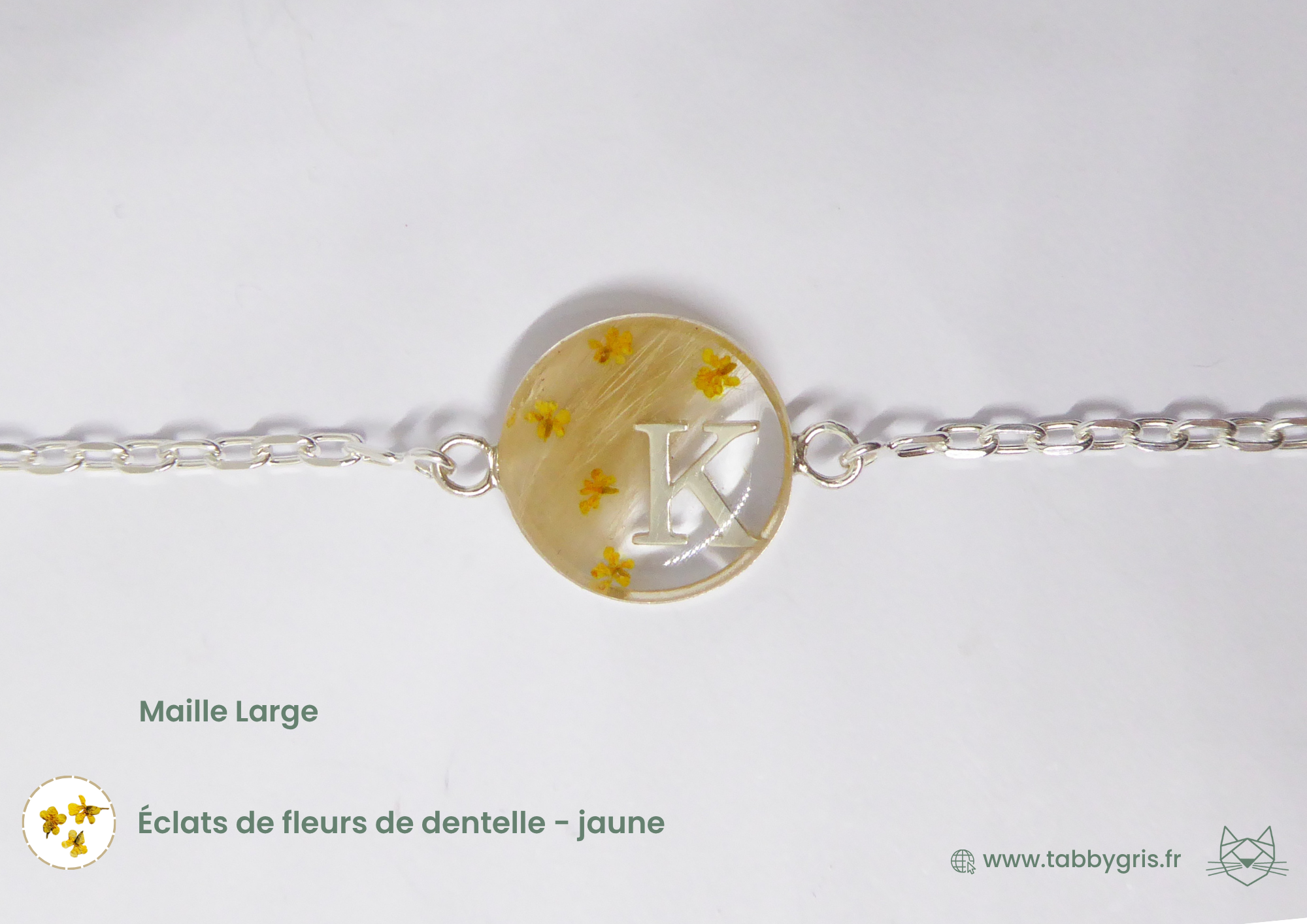 Bracelet souvenir poils animaux avec des poils de hamster, quelques fleurs de dentelle jaunes et une lettre K inclus dans la résine