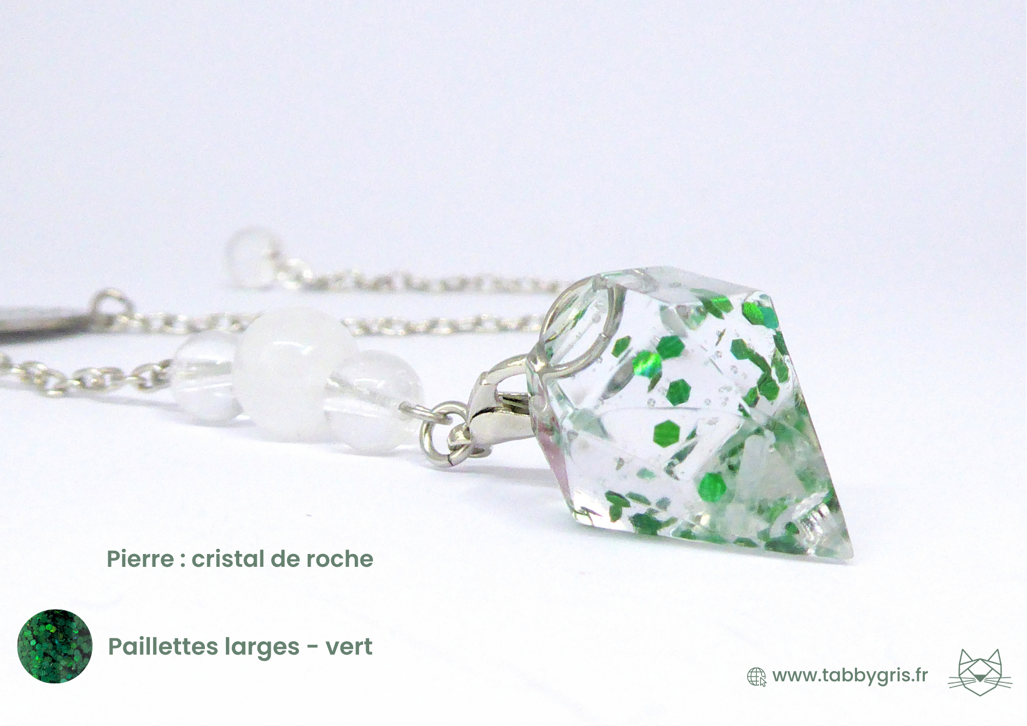 Pendule divinatoire en résine contenant quelques poils de votre animal et des paillettes larges vertes dans la résine. Le pendule est monté sur une chaîne argentée avec un cristal de roche chargé en ondes positives