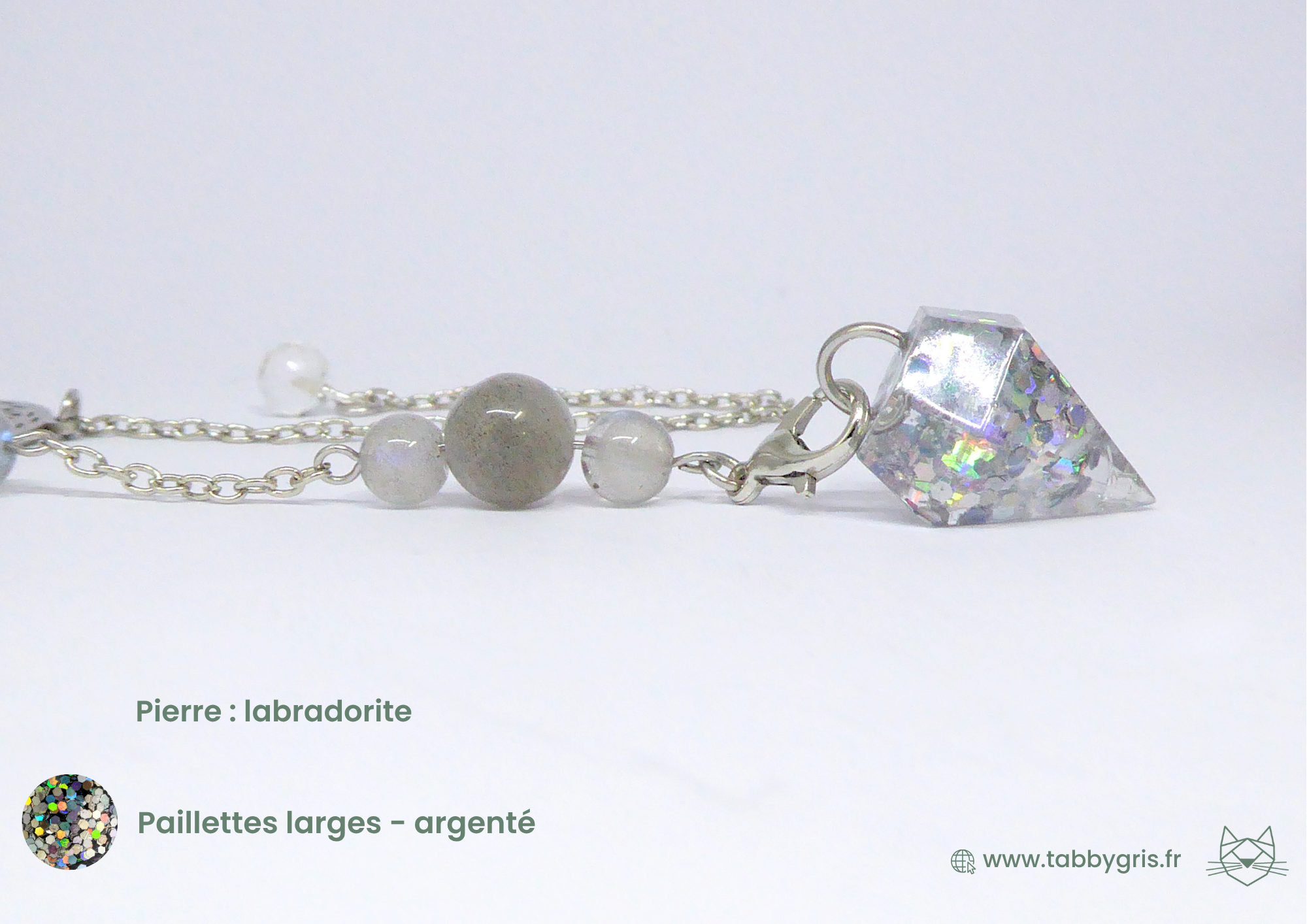 Pendule divinatoire en résine élégant et chic. Il contient de la labradorite, ainsi que des pailletes argenté dans al résine de dernière génération qui résiste aux usures du temps. Personnalisez votre pendule divinatoire comme vous le souhaitez chez Tabby Gris
