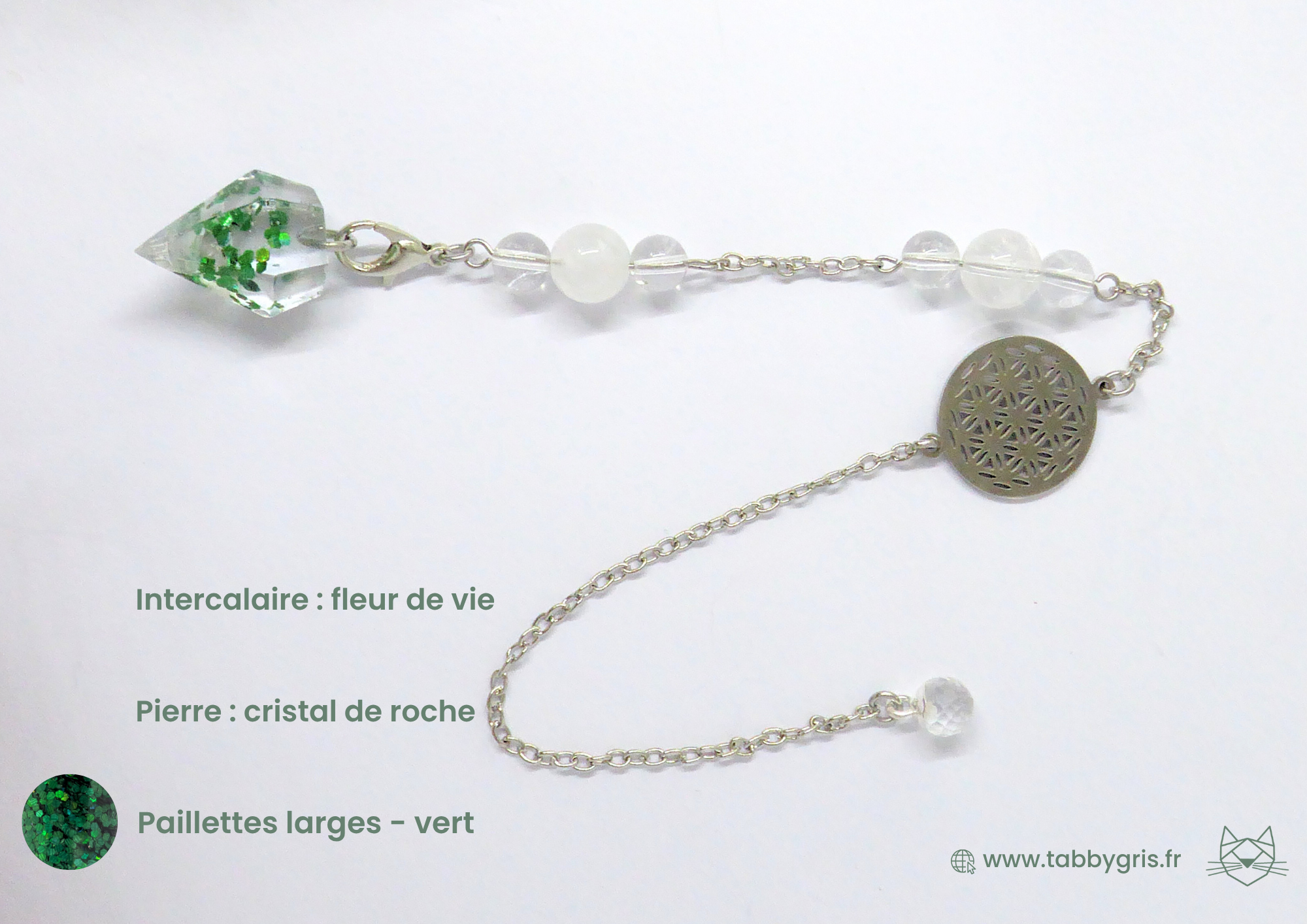 Pendule divinatoire en résinePendule divinatoire en résine avec un intercalaire fleur de vie argenté, un cristal de roche chargé et des paillets larges vertes. Ce pendule personnalisé est l'accessoire parfait pour vos séances de guidance, tirage oracle, tarot, tarot divinatoire et tarot de marseille