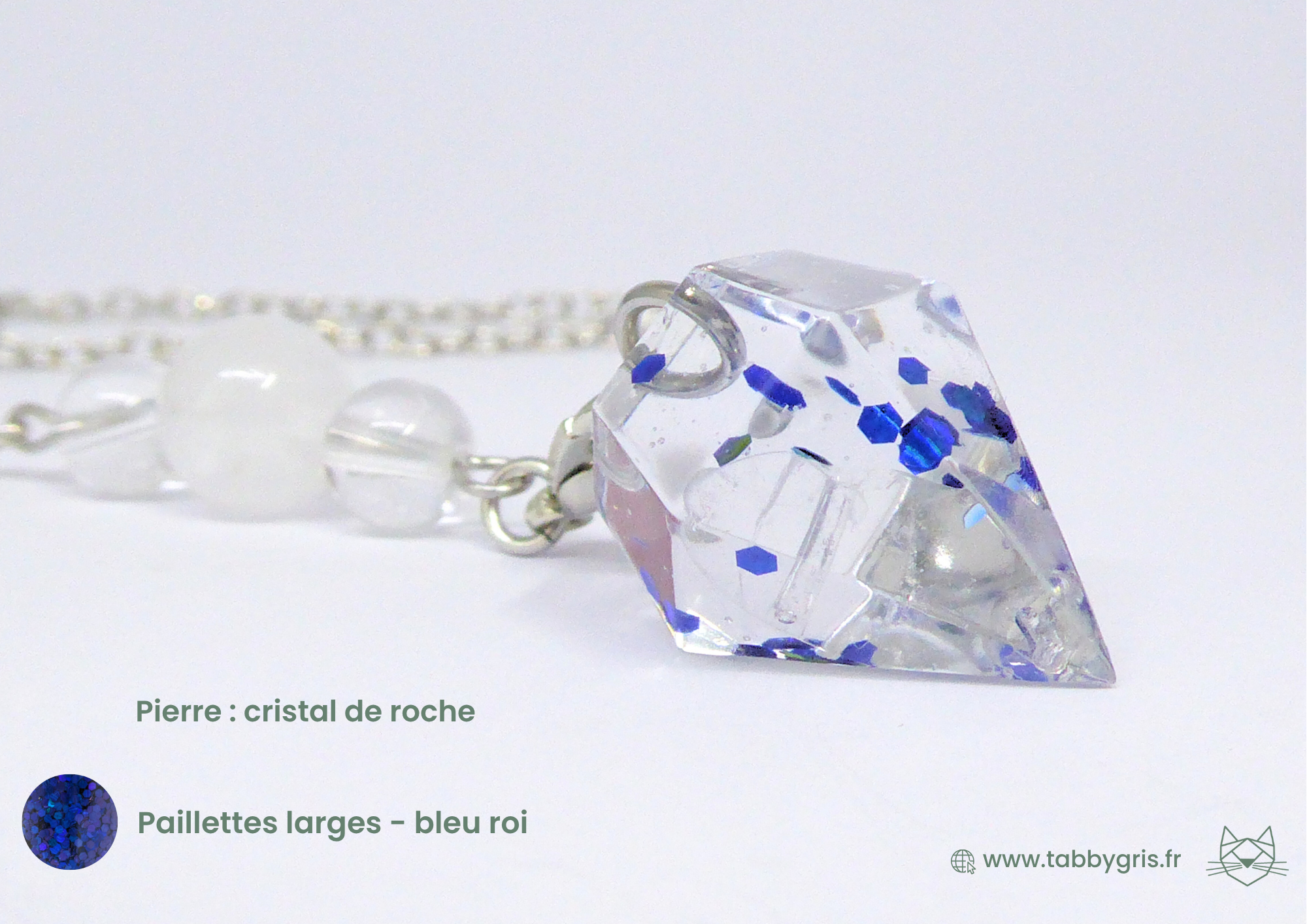 Pendule divinatoire en résine contenant des paillettes larges bleu roi, monté sur une chaîne argentée contenant un cristal de roche