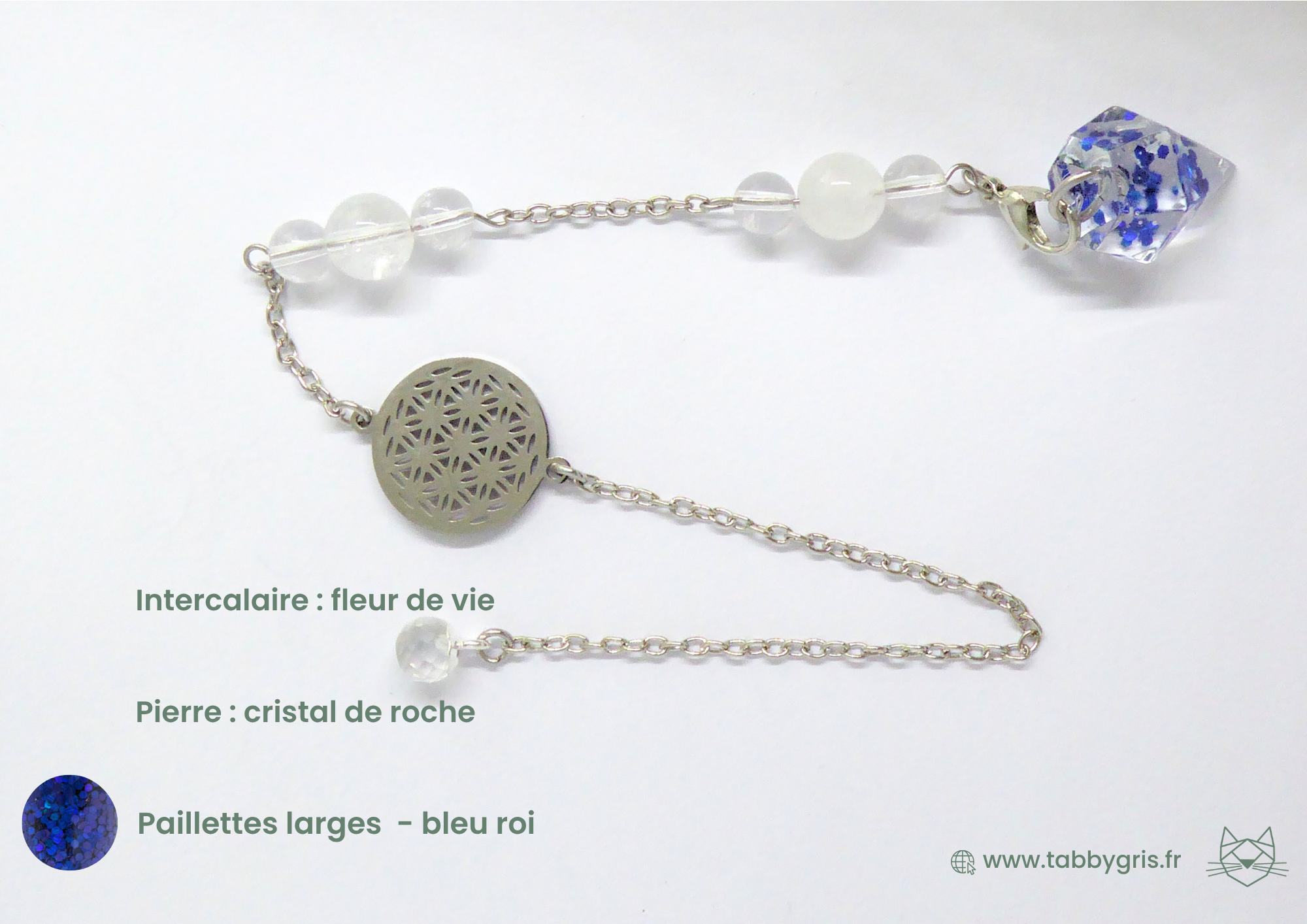 Pendule divinatoire en résine avec intercalaire fleur de vie argenté, cristalle de roche et paillettes larges bleu roi. Ce pendule divinatoire est un outil facile à manier pour un novice et à utiliser quotidiennement par quelqu'un de plus confirmé.