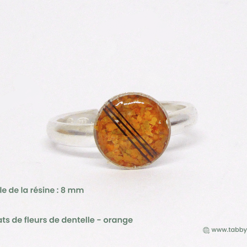 Bague en crin de cheval. Nous glissons quelques crins de votre cheval dans cette bague en résine de dernière génération qui résiste aux usures du temps. Les crins sont placés de façon épurée et sublimés par des éclats de fleurs de dentelle orange.