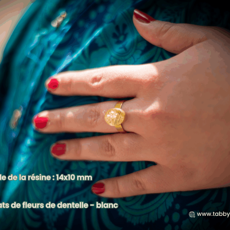 Bijou avec mèche de bébé dans une bague dorée de qualité. Cette bague a une résine de 14x10 mm. A l'intérieur se trouve une partie de la première mèche de cheveux coupée de bébé ainsi que des éclats defleurs dedentelle blanc